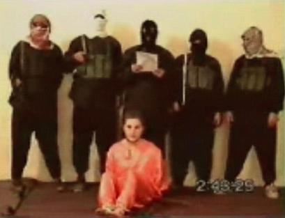 This is an image made from a video posted Tuesday May 11, 2004 on an Islamic Web site affiliated with al-Qaida showing a group of five men wearing headscarves and black ski masks standing over a bound man in an orange jumpsuit, who identified himself as Nick Berg, a U.S contractor whose body was found on a highway overpass in Baghdad on Saturday. (AP Photo via APTN)