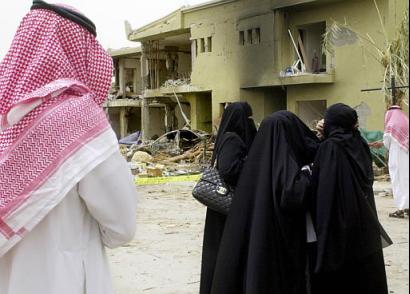 Saudi people in front of destroyed houses following suicide car bombings in eastern Riyadh, Saudi Arabia, at the al-Hamra compound.